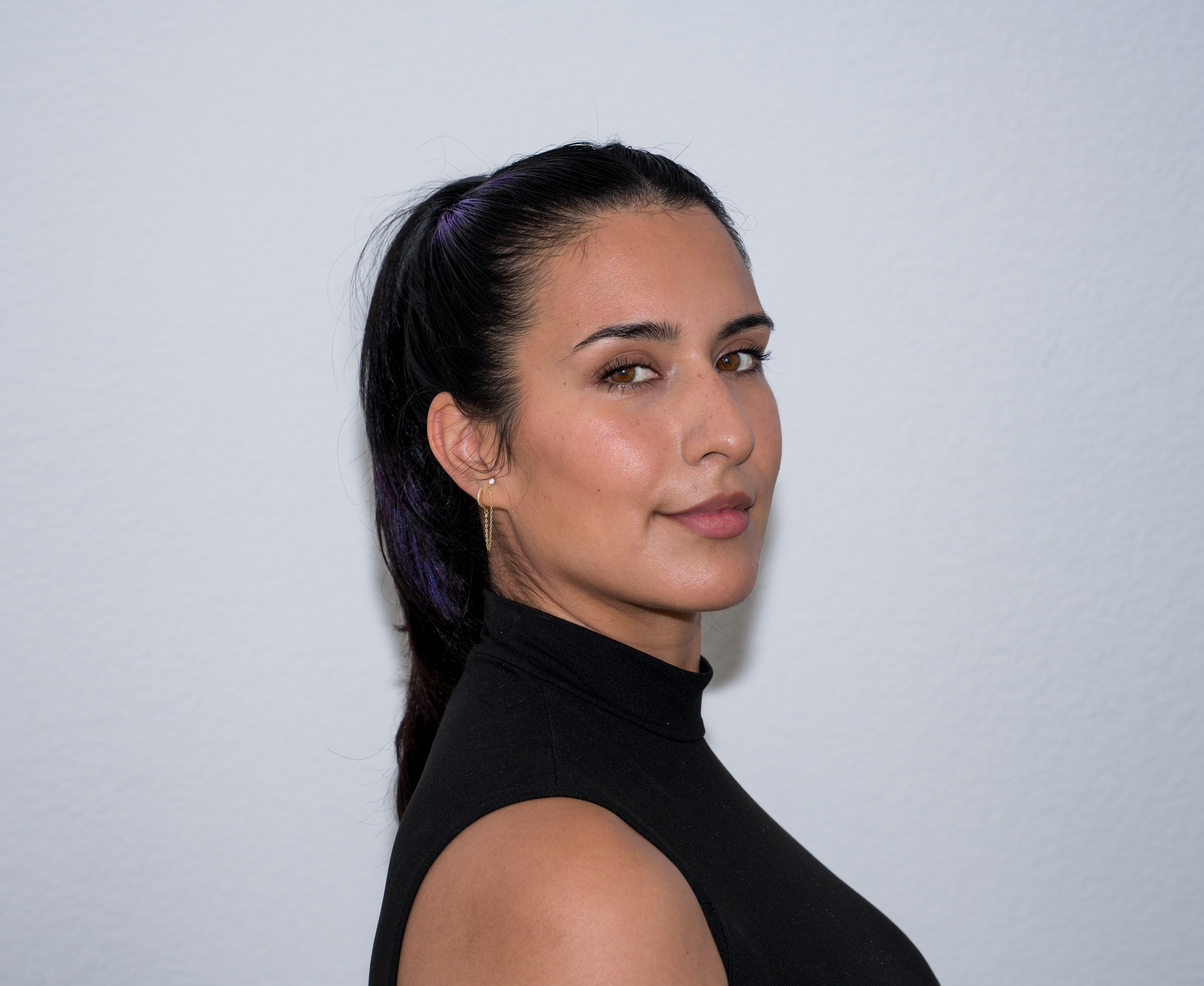 Studio headshot in profile against a pale grey backdrop